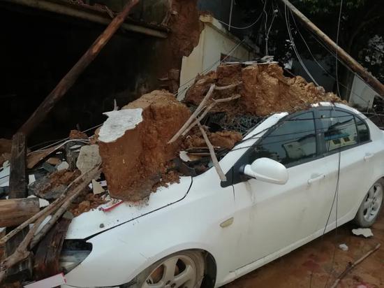 广西荔浦双江镇，暴雨过后路边的轿车被压垮。图/受访者提供