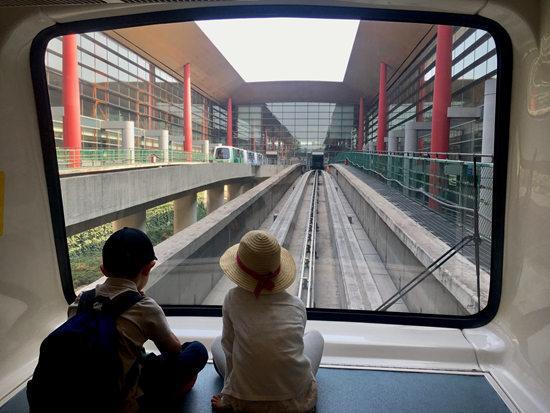 首都机场T3航站楼，前往国际登机口的小火车上，两个孩子并排坐着看着外面。一到假期，首都机场每天进出港人数达到几十万，其中许多是中小学生前往世界各地。笑槑/摄