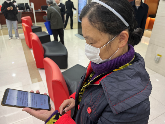  6日上午，63岁武汉市民童女士在工行武汉分行水果湖支行通过手机银行认购养老理财试点产品。新华社记者 邓楠 摄