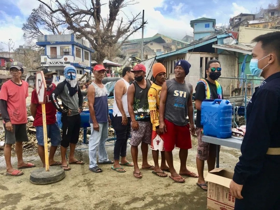 当地时间2021年12月21日，菲律宾迪纳加特，村民排队领取食物。图/IC photo