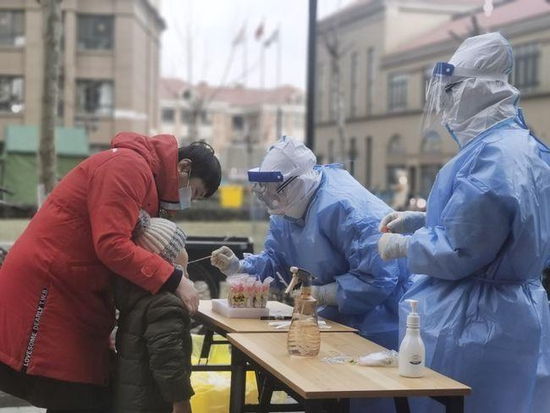 医务人员为天津市津南区居民进行核酸检测取样。新华社记者刘惟真摄。