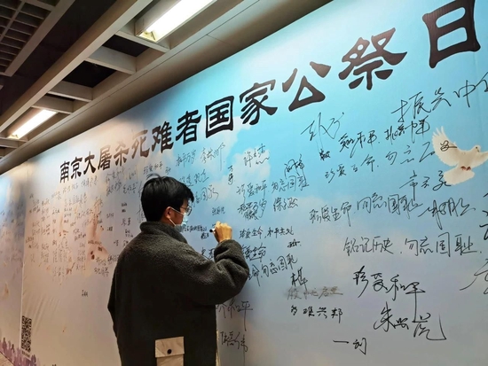  △江苏南京，市民在“南京大屠杀死难者国家公祭日和平许愿墙”上写下心声。