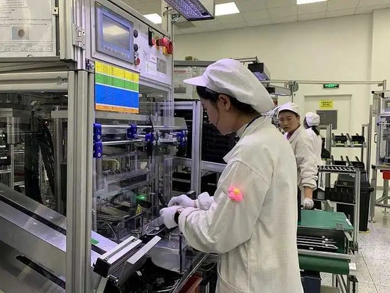 车间里的工人正在逐渐培养起对职业的认同,一名女工在袖子上别了一朵小花。摄影:高佳
