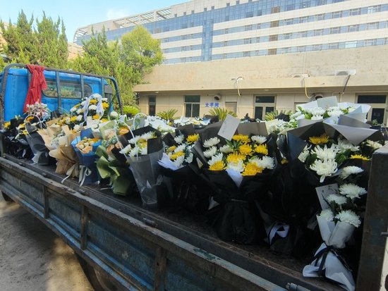 附一醫太平間前,一輛貨車裝滿了悼念李晟醫生的花束 周昱帆 攝