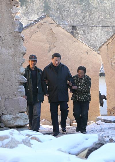 2012年12月29日至30日,习近平在河北省阜平县看望慰问困难群众,考察扶贫工作。这是12月30日,习近平来到地处深山的龙泉关镇骆驼湾村,走进困难群众唐宗秀(右)家慰问看望。(来源:新华社)