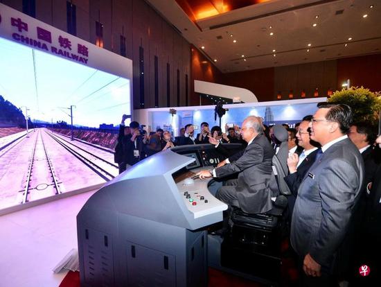 时仍马来西亚总理纳吉布（中）体验试驾中国高铁模拟器 图自联合早报