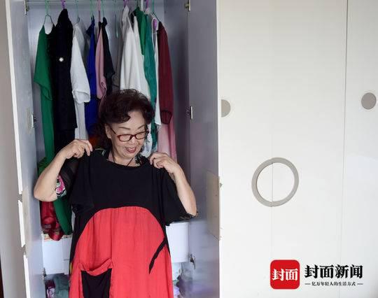  胡金华的衣柜里，各种颜色和款式的衣服整齐挂放着。