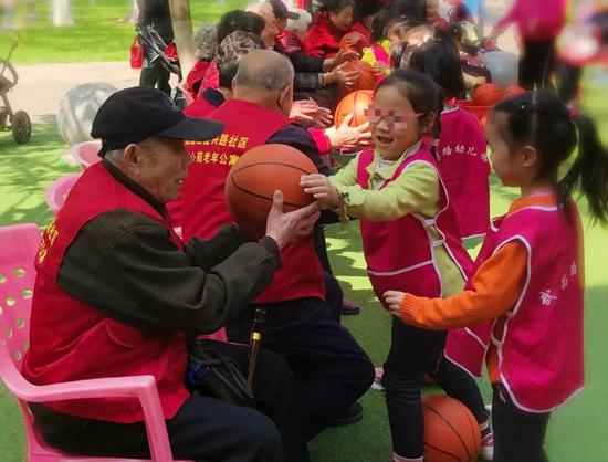 4月1日,童心苑的老幼同乐活动中,孩子和老人们组队比赛传球。新京报记者王翀鹏程 摄