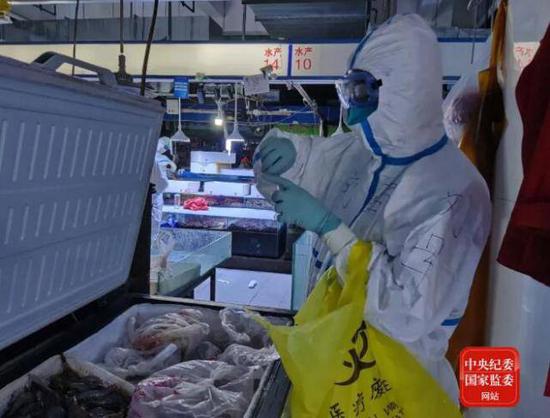 6月14日20时44分,中国疾控中心病毒病所溯源专家组成员在新发地农产品批发市场内采集冷冻海鲜样本。