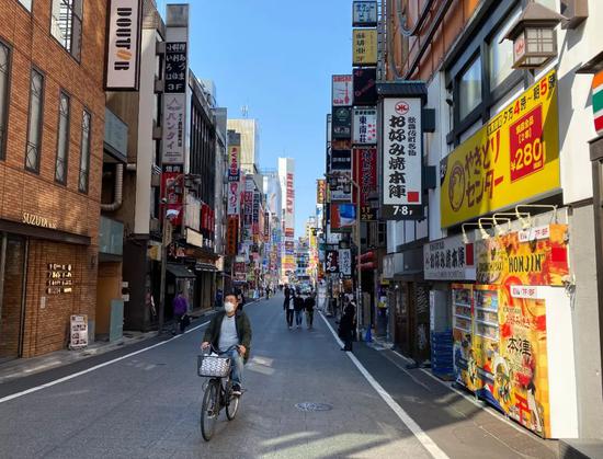 2020年4月2日,戴着口罩的行人从新宿东口歌舞伎町一番街前走过。