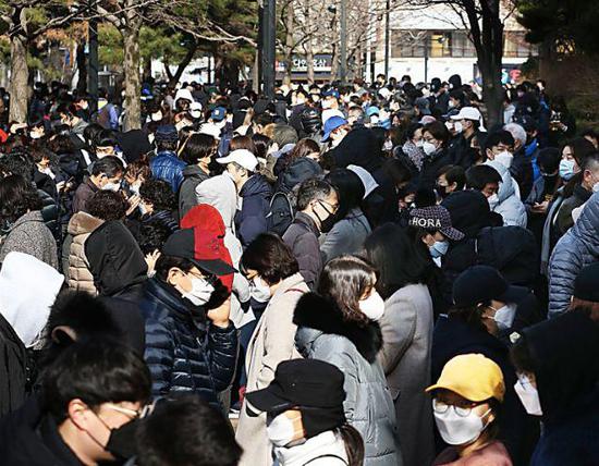 24日,韩国大邱市民列队购置口罩