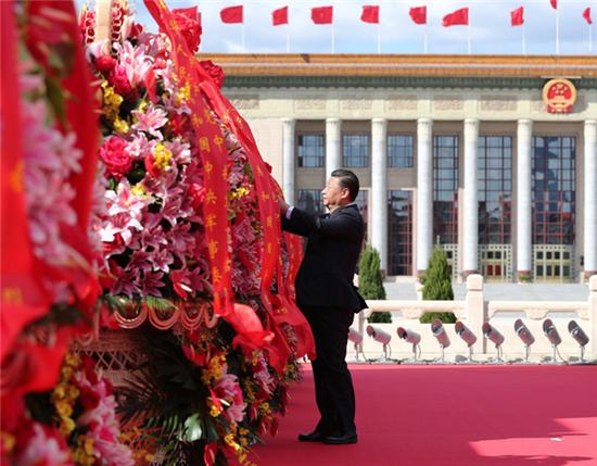 2018年9月30日上午,党和国家领导人习近平在北京天安门广场出席烈士纪念日向人民英雄敬献花篮仪式时整理花篮上的缎带。