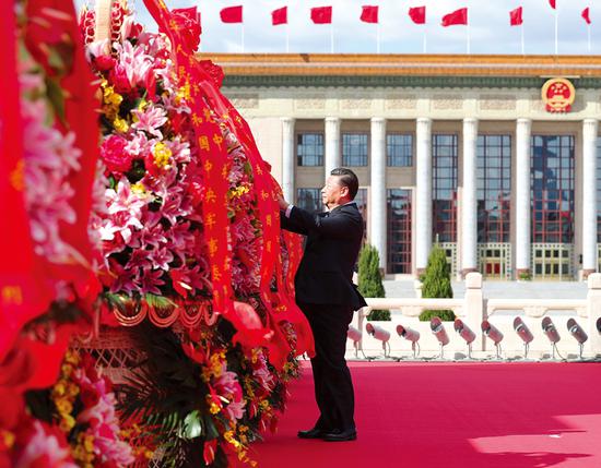 2018年9月30日上午，党和国家领导人习近平、李克强、栗战书、汪洋、王沪宁、赵乐际、韩正、王岐山等来到北京天安门广场，出席烈士纪念日向人民英雄敬献花篮仪式。这是习近平整理花篮上的缎带。 新华社记者 谢环驰/摄