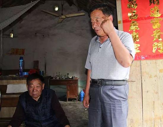  ?案发时，周家华的父亲（右）担任村干部，警方因其“不支持”破案工作而将其在看守所关了8个月 