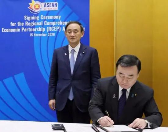 日本经济产业相梶山弘志(右)及首相菅义伟签署RCEP协定