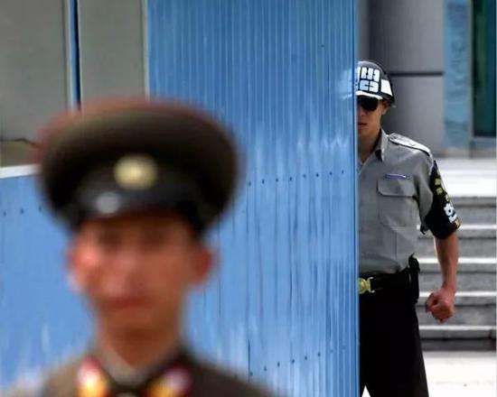 2002年9月19日拍摄的资料照片显示，一名韩国宪兵（右）和一名朝鲜人民军士兵在板门店朝鲜半岛军事分界线两侧执勤。新华社记者龚兵摄