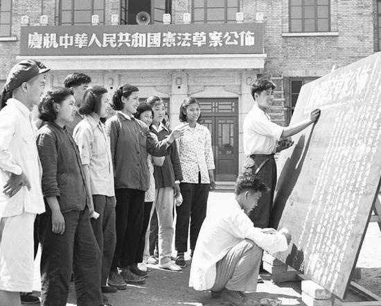 1954年9月第一届全国人民代表大会通过的《中华人民共和国宪法》，反映了全国人民的共同意愿。此前，在宪法草案公布后，全国共有1．5亿人参与了讨论，提出意见118万多条。图为1954年6月15日，北京国营第一棉纺织厂工人们获悉《中华人民共和国宪法草案》公布的消息后，立刻出版黑板报宣传。新华社记者 吴化学／摄