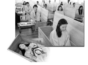 图片

　　▲参加“葬礼”的员工躺进棺材，抱着自己的“遗像”。棺材盖上后，在一片黑暗中，他们会有10分钟安静地思考人生的意义。