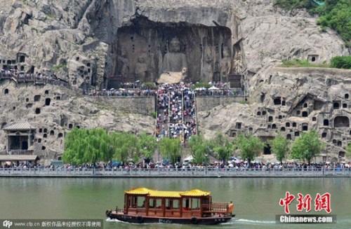 资料图。2015年5月2日，河南洛阳，“五一”假期第二天，龙门石窟游人如织。图片来源：CFP视觉中国