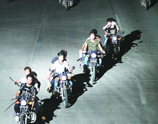 2015年4月30日，广东揭阳，一群90后夜晚开着摩托车动辄数十人在公路上上演“速度与激情”，手持砍刀、九环刀等无端殴打砍伤路人。嫌犯“阵势”不小。（警方提供的监控视频截图）（资料配图）视觉中国供图