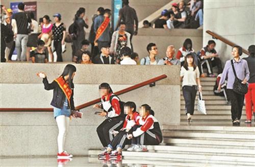 2014年5月份，博物馆内，文明引导员劝游客不要坐在台阶上。摄影：记者袁艺 图片来源：北京青年报