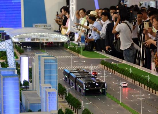 5月19日，观众在科博会上参观“巴铁”模型。“巴铁”是一种依靠电力驱动的大运量宽体高架电车，将城市快速公交与地铁融为一体。新华社记者 张晨霖 摄
