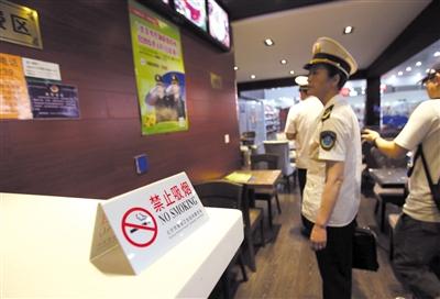 2015年6月1日,铁路卫生监督工作人员在北京西站一咖啡厅内检查是否有禁烟标识。新京报记者 王贵彬 摄