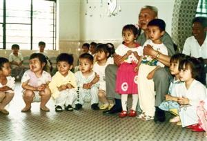 1993年5月寇庆延同志视察省水电二局时与幼儿园小朋友在一起。