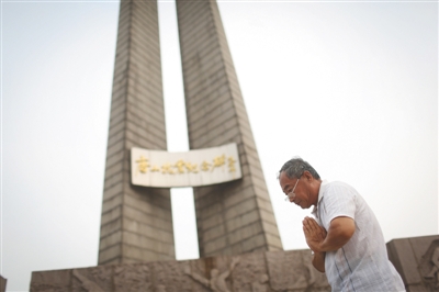 7月17日，唐山抗震纪念碑前，一位老者双手合十纪念祈福。新京报记者 侯少卿 摄