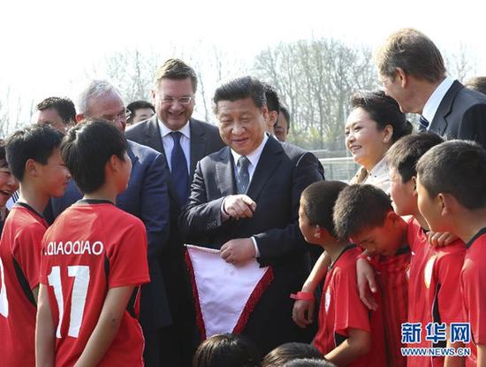 2014年3月29日，国家主席习近平来到柏林奥林匹亚体育场足球场，亲切看望在德国训练的来自陕西志丹县的中国少年足球运动员。 新华社记者兰红光摄