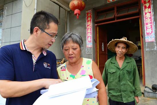 9月12日，古田县纪委工作人员（左）在水口镇湾边村低保户刘兴龙家了解扶贫资金领取情况。近年来，福建省级扶贫开发重点县古田县纪委将查处扶贫领域违纪违规问题，作为整治侵害群众利益的不正之风和腐败问题的重点工作，以“精准监督”为“精准扶贫”保驾护航，努力杜绝扶贫领域虚报冒领、截留私分、挥霍浪费等问题发生。新华社记者魏培全摄