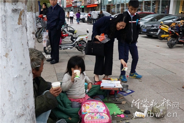 过路的爱心市民给女孩放下了热饮和零钱。