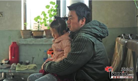 11月8日,乌市天山区东大梁街一处住房内,刚出院不久的欣欣要爸爸抱着。亚心网记者豆兴军摄