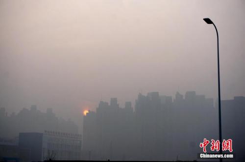 资料图：2016年1月3日，河南郑州雾霾笼罩着的高楼大厦。 中新社记者 王中举 摄