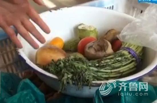  在王大娘家的屋里记者看到地上放了很多菜，很整齐，新鲜的胡萝卜西红柿，这些是她自家种的，而盆里这些看起来蔫了的菜是王大娘捡回来自己吃的 