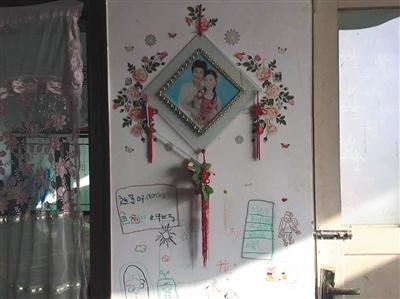 11月27日,河北白范疃村,白海朋夫妻合影下是女儿涂鸦。