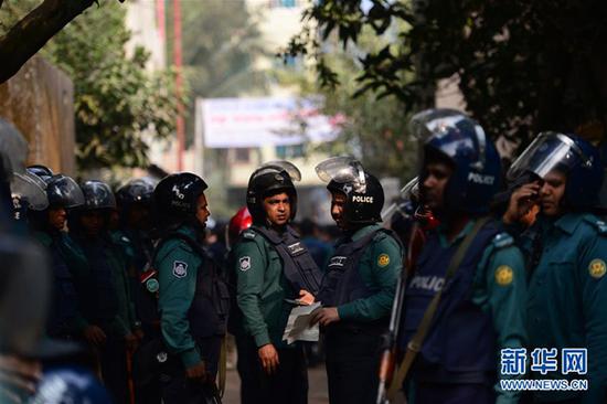  12月24日，在孟加拉國達卡，警察在圍捕行動現場警戒。孟加拉國警方當日上午在首都達卡對一處被取締的極端組織成員的藏匿處實施圍捕，逮捕4人。另有兩名武裝分子引爆身上炸彈身亡。 新華社/法新