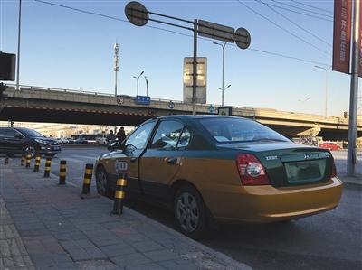 丰台区花乡桥附近，车贩子将一辆下线出租车停在路边等待买家。