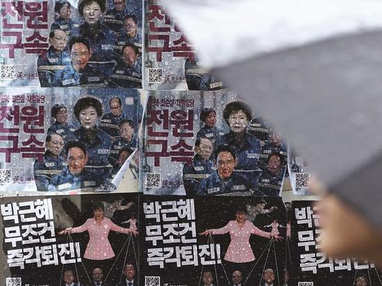 首尔，公交车站广告牌上粘贴着要求逮捕朴槿惠和其亲信崔顺实及相关人员的抗议宣传画。（新华/美联）