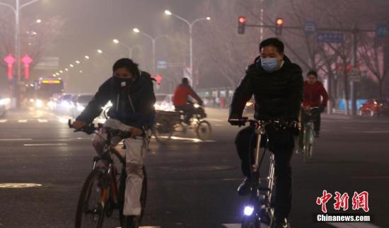  1月3日，北京持续重度雾霾天气，民众戴口罩骑行在街头。中新社记者 杨可佳 摄  