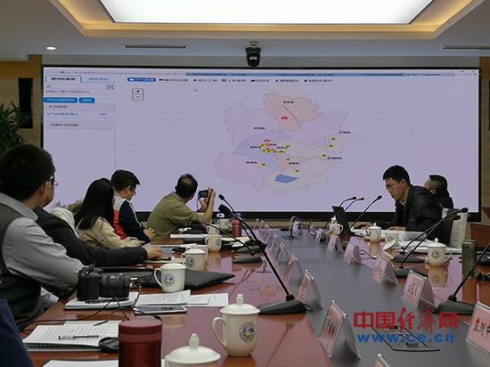 天津市环保局工作人员在进行操作演示,向采访团讲解地图上的行政区划与治污网格一一对应。(中国经济网记者范戴芫 摄)
