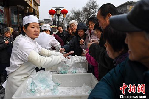 2017年2月7日，不少北京市民在一家传统北京小吃店购买该店手工制作的传统清真元宵。中新社记者 崔楠 摄