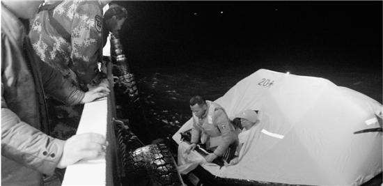 救援人员把渔民一个一个拉上救援船。