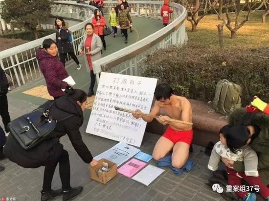 ▲2017年1月,北京地铁复兴门站出口附近,好心人在向“打股救子”的樊富贵捐款。 图片来源:东方IC。