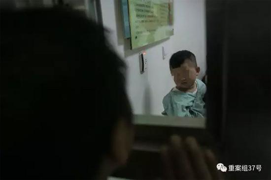 ▲2月21日晚,樊富贵与在病房里的儿子透过探视窗打招呼。 新京报记者 彭子洋 摄