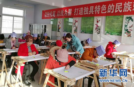 赵秀兰（中）在刺绣培训班教授学员刺绣技艺（2016年12月15日摄）。新华社发