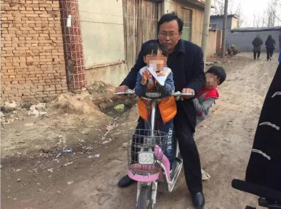 杜志浩的父亲杜洪章用电动车接送两个孩子