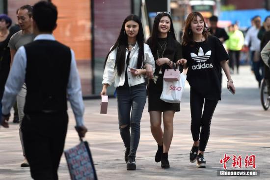 图为北京三里屯街头的姑娘小伙们换上夏装出行。 中新网记者 金硕 摄