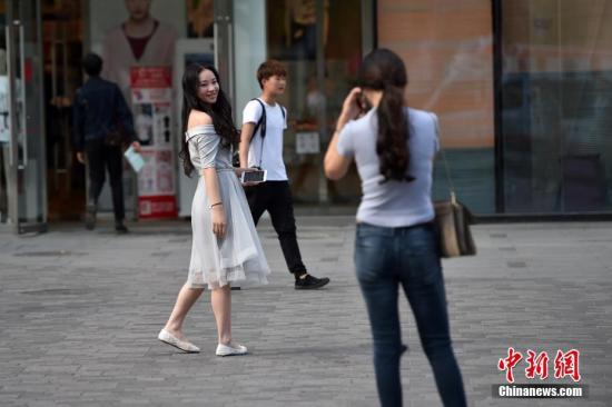 图为北京三里屯街头的姑娘小伙们换上夏装出行。 中新网记者 金硕 摄