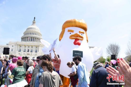  当地时间4月15日，抗议民众在美国首都华盛顿的国会山附近举行反特朗普示威游行。中新社记者 邓敏 摄